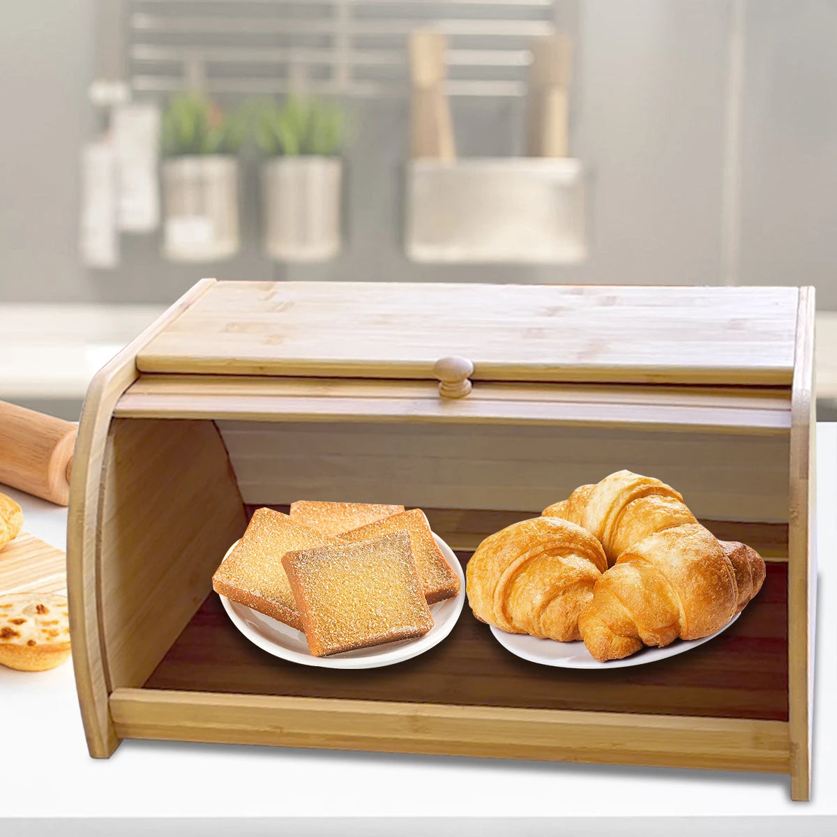 Bamboo roll-top bread box with croissants on a kitchen counter
